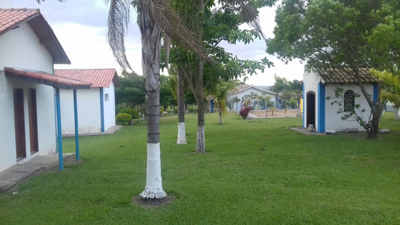 Casinhas brancas de detalhes azuis espalhadas pelo gramado