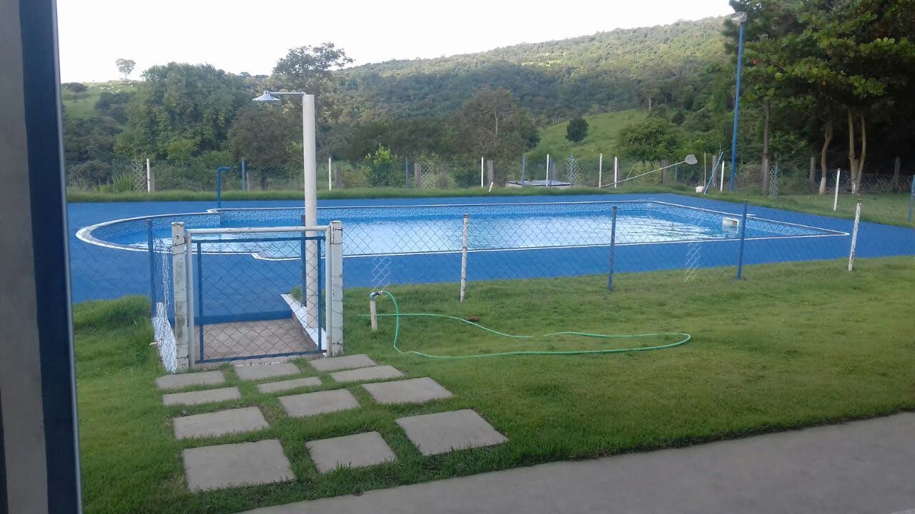Entrada da área da piscina com caminho de pedras no gramado